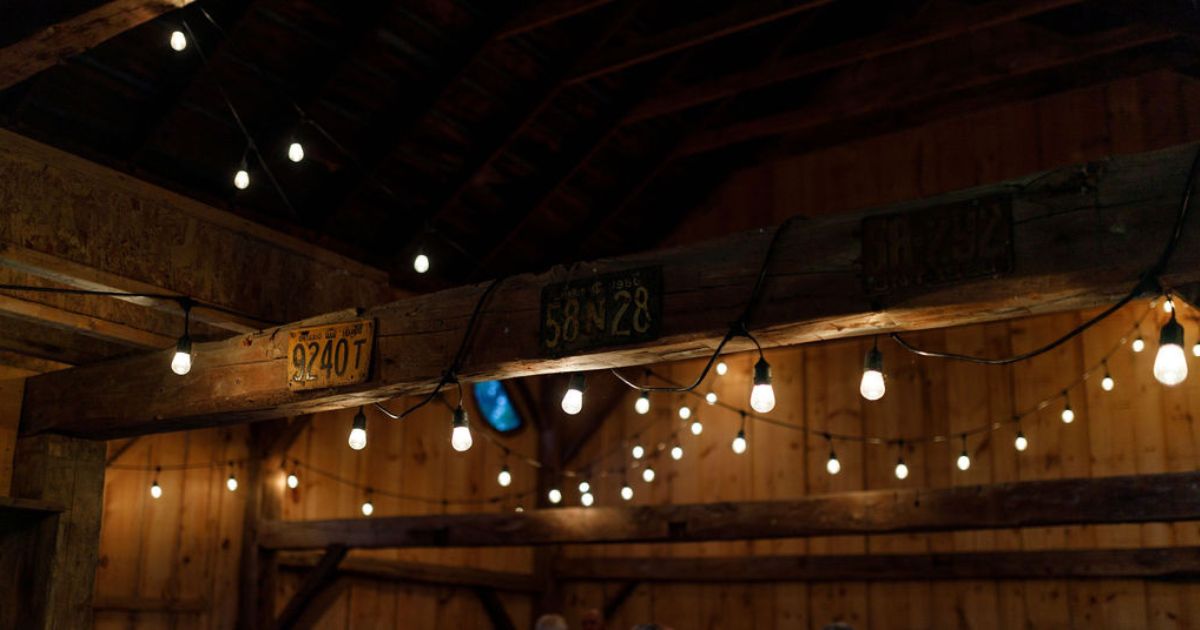 A cozy barn concert setting with soft lighting and an intimate crowd.